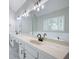 Elegant bathroom featuring dual sinks, a large mirror, modern lighting, and a decorative window for added style at 1096 Polo Club Nw Dr, Marietta, GA 30064
