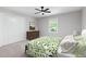 Comfortable bedroom with a leafy comforter, a ceiling fan, double door closet, and a sunny window at 1096 Polo Club Nw Dr, Marietta, GA 30064