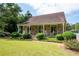 Charming stone home features a covered porch, rocking chairs, and well-manicured landscaping at 1096 Polo Club Nw Dr, Marietta, GA 30064