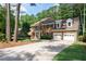Elegant brick home with a two-car garage and a long driveway surrounded by lush greenery at 1096 Polo Club Nw Dr, Marietta, GA 30064
