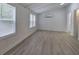 Bedroom featuring gray vinyl plank flooring, white wainscoting, and two windows at 12208 Buchanan Hwy, Temple, GA 30179
