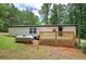 Exterior view of property with a nice back porch, a propane tank, and wooded surrounding at 12208 Buchanan Hwy, Temple, GA 30179