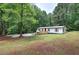 Charming home exterior featuring a welcoming front porch and lush greenery at 12208 Buchanan Hwy, Temple, GA 30179