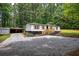 Charming home featuring a newly constructed wood deck, landscaped yard, and a gravel driveway at 12208 Buchanan Hwy, Temple, GA 30179