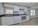 Kitchen with white cabinets, stone countertops, white appliances, and wainscoting at 12208 Buchanan Hwy, Temple, GA 30179