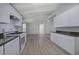 View of the kitchen and living area featuring white cabinets and gray vinyl plank flooring at 12208 Buchanan Hwy, Temple, GA 30179