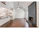 Open-concept living room featuring a dark brick fireplace, wood floors, and an adjacent modern kitchen at 1731 Twin Brooks Se Dr, Marietta, GA 30067