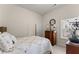 Sunlit bedroom showcasing a bed, dresser, and serene window view at 6460 Valley Crossing Way, Cumming, GA 30028