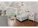 A primary bedroom with hardwood floors, sitting area, and a tray ceiling at 6460 Valley Crossing Way, Cumming, GA 30028
