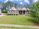Charming single story home with stone exterior and manicured lawn features covered front porch at 6460 Valley Crossing Way, Cumming, GA 30028