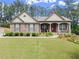 Charming single story home boasts brick and stone exterior with a well-manicured lawn and inviting covered porch at 6460 Valley Crossing Way, Cumming, GA 30028