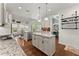Gourmet kitchen with granite counters, stainless appliances, and center island is open to living spaces at 6460 Valley Crossing Way, Cumming, GA 30028
