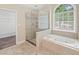Bright bathroom features a glass shower, jacuzzi tub, and window at 740 Orchard Ct, Atlanta, GA 30328