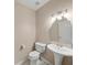 Half bathroom with pedestal sink, toilet, and decorative mirror at 740 Orchard Ct, Atlanta, GA 30328