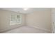 Empty, neutral-toned bedroom with a window, blinds, and light-colored carpet at 740 Orchard Ct, Atlanta, GA 30328