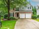 Charming two-story home with brick and gray siding, well-manicured lawn, and a two-car garage at 740 Orchard Ct, Atlanta, GA 30328