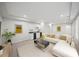 Bright living room with bar, white sofa, yellow artwork, and patterned rug at 740 Orchard Ct, Atlanta, GA 30328