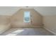Attic bedroom features a window, angled ceilings, and natural light, creating a unique space at 1615 Burnt Oak Way, Dacula, GA 30019