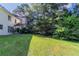 Lush backyard featuring expansive green space, mature trees, and partial views of the home at 1615 Burnt Oak Way, Dacula, GA 30019