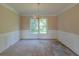 Traditional dining room featuring wainscoting, elegant chandelier, and a large window at 1615 Burnt Oak Way, Dacula, GA 30019