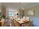 Staged dining room with chandelier, table set for six, columns, and adjacent sitting area at 1615 Burnt Oak Way, Dacula, GA 30019