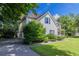 Side view of a two-story house with blue shutters, green landscaping, and paved driveway at 1615 Burnt Oak Way, Dacula, GA 30019