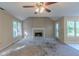 Empty living room with fireplace, ceiling fan, large windows, and worn carpet at 1615 Burnt Oak Way, Dacula, GA 30019