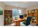 Cozy home office featuring built-in bookshelves, a large window, and comfortable chair at 1615 Burnt Oak Way, Dacula, GA 30019