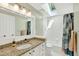 Bright bathroom featuring a granite countertop, a large mirror, and a shower-tub combination with a skylight at 4619 Villa Chase Ne Dr, Marietta, GA 30068