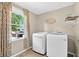 Well-lit laundry room with a modern washer and dryer, complemented by stylish decor and natural light at 4619 Villa Chase Ne Dr, Marietta, GA 30068