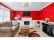 Inviting living room with a cozy fireplace, bright red accent wall, and modern furnishings at 4619 Villa Chase Ne Dr, Marietta, GA 30068