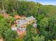Aerial view of a beautiful home with a red-tiled patio surrounded by lush, mature trees at 570 Matterhorn Way, Alpharetta, GA 30022