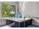 The bathroom boasts natural light and a corner bathtub with tiled detailing for a modern aesthetic at 570 Matterhorn Way, Alpharetta, GA 30022