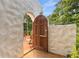 Charming arched doorway leads to a private courtyard with terracotta tile and outdoor seating at 570 Matterhorn Way, Alpharetta, GA 30022