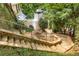 Stone steps lead to a unique backyard space with manicured landscaping and architectural details at 570 Matterhorn Way, Alpharetta, GA 30022