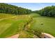 Scenic aerial view of a golf course with meticulously maintained fairways and a winding stream at 570 Matterhorn Way, Alpharetta, GA 30022