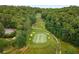 Aerial view of a well-designed golf course featuring sand traps, a golf cart, and lush surrounding trees at 570 Matterhorn Way, Alpharetta, GA 30022