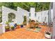 Charming patio features terracotta tile, dining set, outdoor fireplace, and greenery at 570 Matterhorn Way, Alpharetta, GA 30022