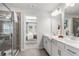 Bright bathroom featuring double vanity with white cabinets, quartz countertop, and glass shower at 206 Maycrest Path, Tucker, GA 30084