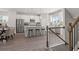 Bright open-concept kitchen boasts a large island with bar seating and stainless steel appliances, complemented by a staircase at 206 Maycrest Path, Tucker, GA 30084