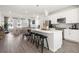 Bright kitchen with white cabinetry, stainless appliances, and a large island with bar seating opens to the living area at 206 Maycrest Path, Tucker, GA 30084