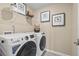 Modern laundry room with white front loading GE washer/dryer set and wire shelving above at 206 Maycrest Path, Tucker, GA 30084