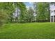 Expansive grassy backyard surrounded by mature trees and greenery at 383 Oakridge Dr, Cartersville, GA 30121