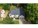 Aerial view of the home showing mature landscaping, backyard playground and driveway with garage at 525 Old Path Xing, Roswell, GA 30075