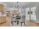 Dining area with hardwood floors, view of kitchen, modern light fixture, and French doors to sunroom at 525 Old Path Xing, Roswell, GA 30075