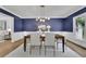 Chic dining room featuring dark wood table, modern chandelier and decor plus hardwood floors and wainscotting at 525 Old Path Xing, Roswell, GA 30075