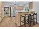 Eat-in kitchen with stainless refrigerator, light wood cabinets, counter seating, and view into the dining room at 525 Old Path Xing, Roswell, GA 30075