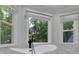 Luxurious bathroom features a standalone tub, view of the backyard, and bright natural light at 525 Old Path Xing, Roswell, GA 30075