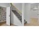 Stylish staircase featuring carpeted steps, black iron railing, and unique wallpaper design at 525 Old Path Xing, Roswell, GA 30075