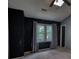 Bedroom featuring a window, ceiling fan, carpet flooring, vaulted ceiling, and dark chalkboard accent wall at 1696 Hunting Creek Dr Se, Conyers, GA 30013